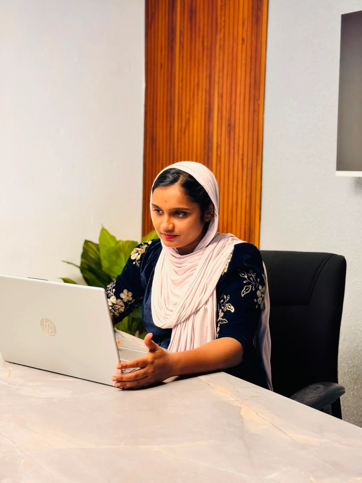Professional woman sitting at a desk in an office, representing a freelance social media strategist working on digital marketing